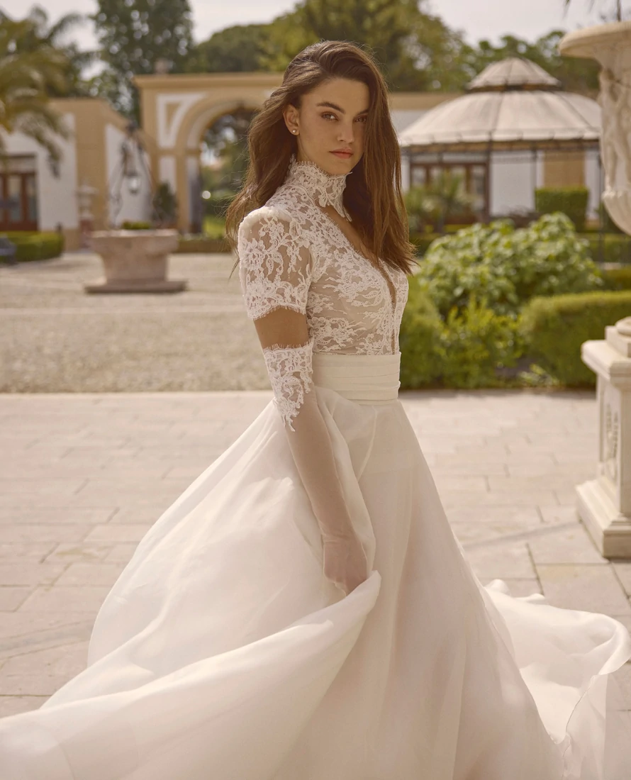 Immagine di una sposa di una sposa girata di spalle, con un abito meraviglioso. sfondo, parete bianca